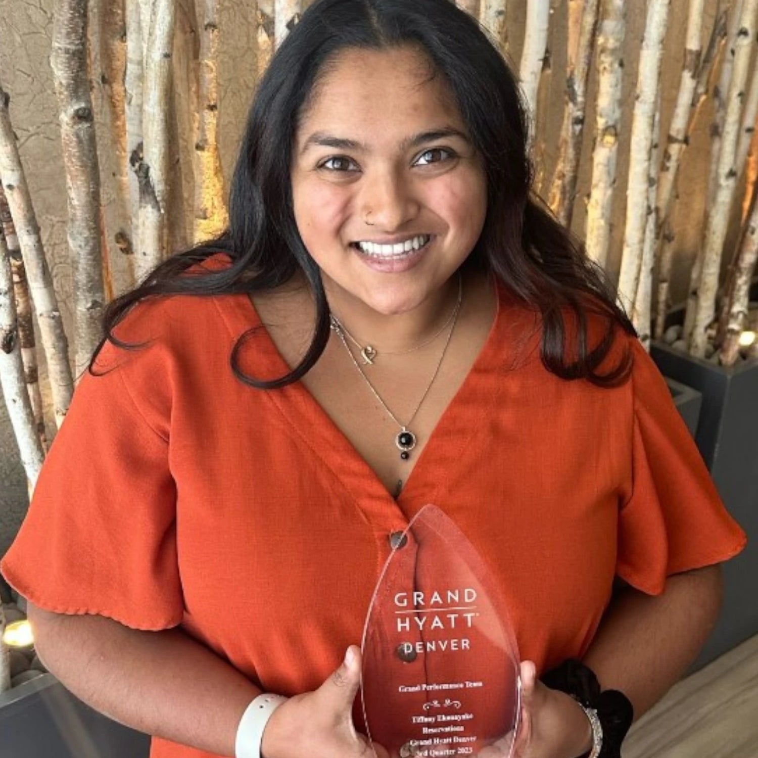 Hospitality Leader Holding Customized Glass Award from Grand Hyatt