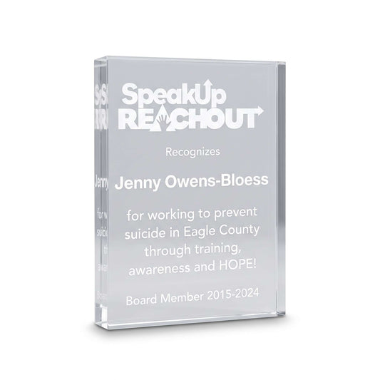 A clear acrylic award plaque featuring engraved white text that reads 'SpeakUp REACHOUT' and recognizes Jenny Owens-Bloess, with additional text below on a clean white background.