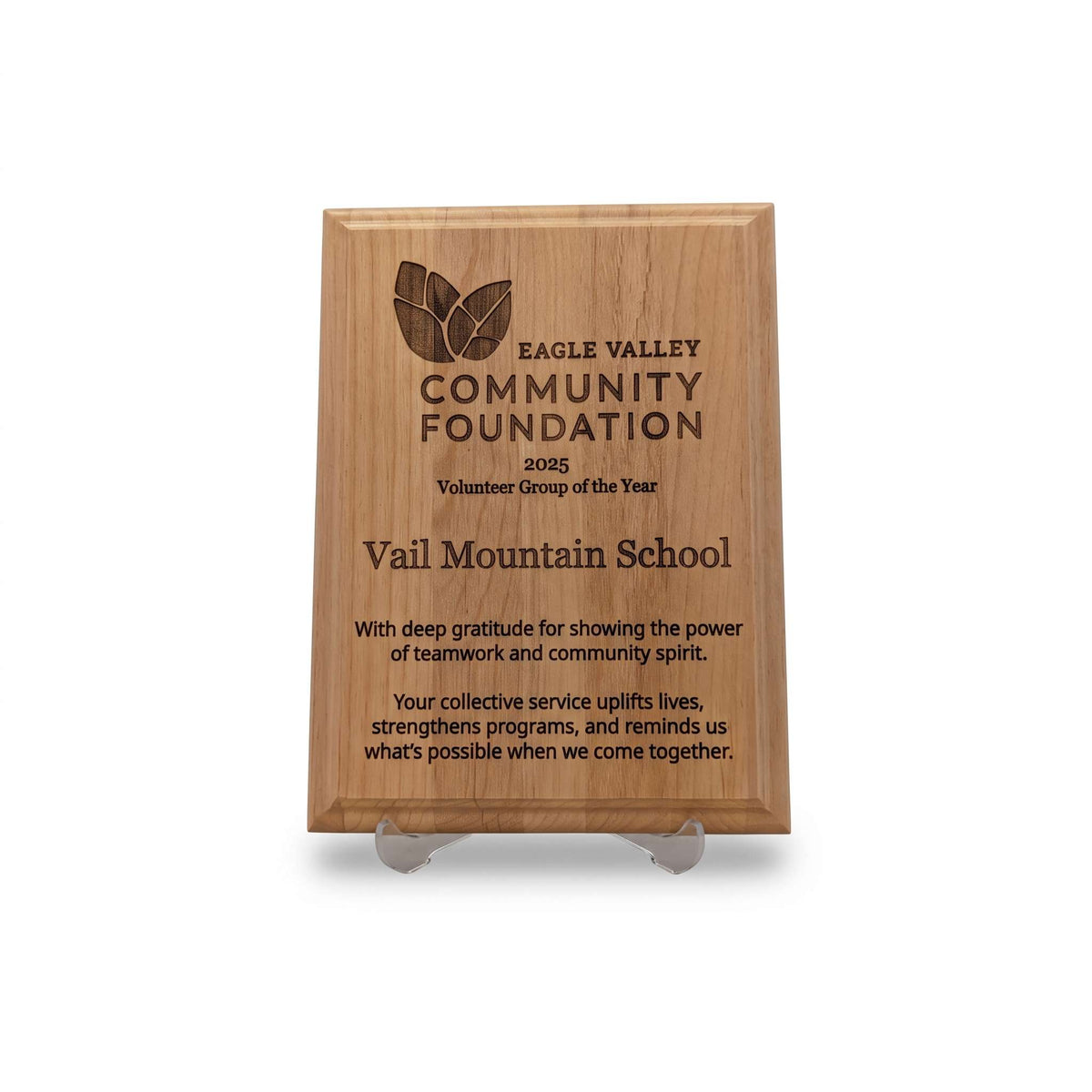 A rectangular engraved wooden plaque on a clear acrylic display stand, featuring the Eagle Valley Community Foundation 2005 Volunteer Group of the Year award for Vail Mountain School.