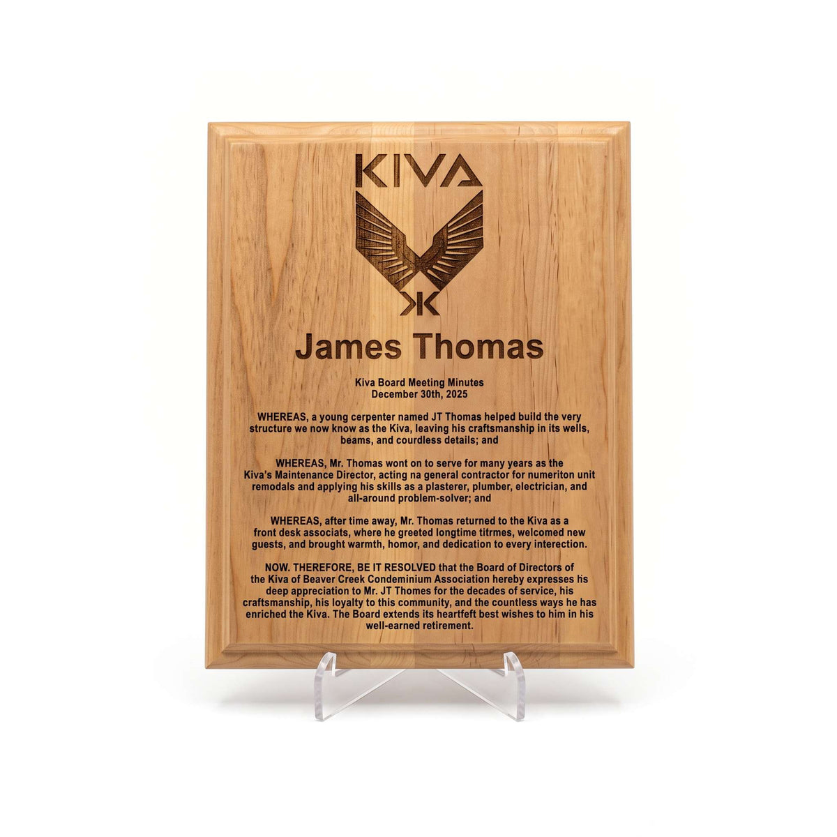 A rectangular wooden engraved plaque on a clear acrylic stand, featuring the Kiva logo and personalized text for James Thomas. In recognition of his years of service to the property.