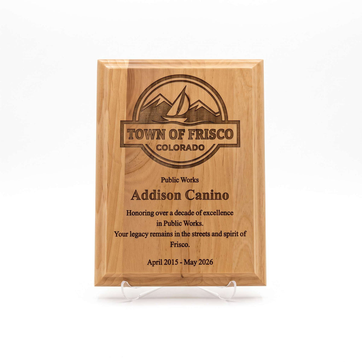 A rectangular wooden plaque on clear acrylic display stands, engraved with the Town of Frisco Colorado logo and personalized text recognition for Addison Canino for her years of service, shown against a plain white background.