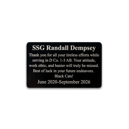 A black rectangular memorial plaque with rounded corners and white text reading 'SSG Randall Dempsey' followed by a memorial message and dates, shown on a plain white background.