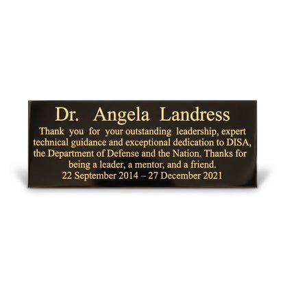 A rectangular black memorial plaque with gold lettering, shown on a clean white background with a soft shadow. The plaque is personalized with the name 'Dr. Angela Landress in recognition for her leadership and dedication to DISA, the Department of Defense and the Nation.