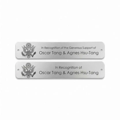 Two rectangular silver metal nameplates with rounded corners, featuring a black engraved U.S. logo 